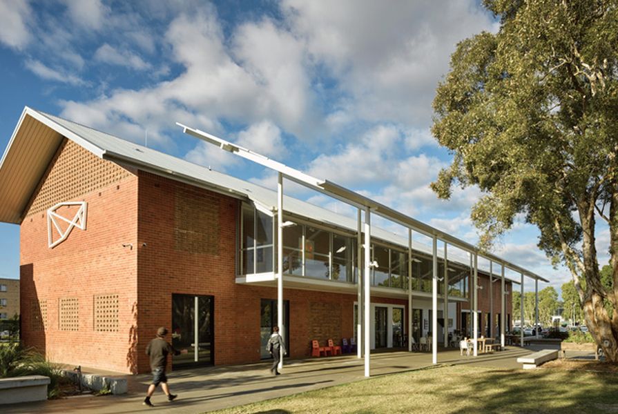 The new work is clearly articulated off the side of a 1960s red-brick building. A fly roof and colonnade encourage occupation of the outside space.