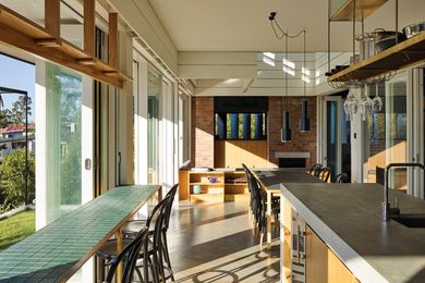 The white timber boards emphasize the sitting room’s verticality, while the brick references the area’s masonry tradition.