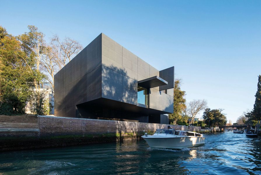 The brooding black box cantilevers over the canal, its recessed ground floor housing service areas and an office.