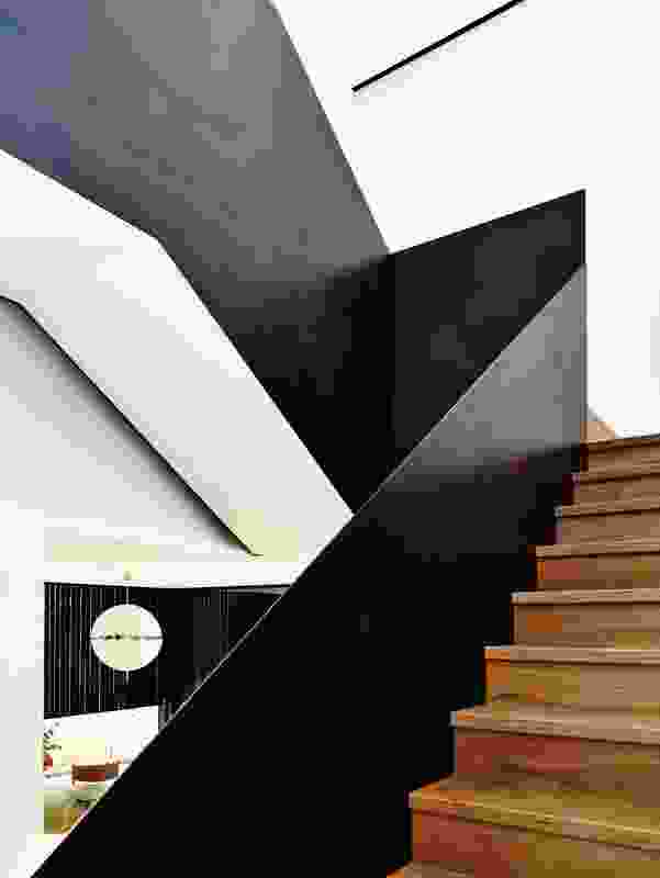 A sculptural black steel balustrade, sealed with black boot polish, lines the stair.