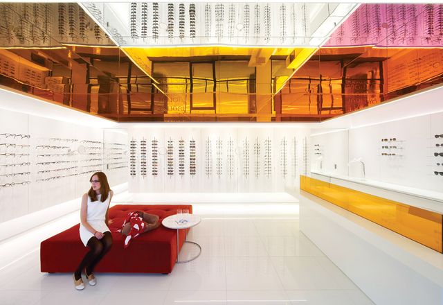 The optometry store's trademark is it's colourful mirror and glass canopy which reflects colour and light around the space.