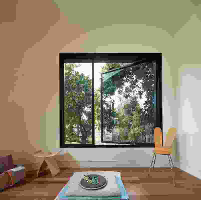 A large window opens to the garden, encouraging a connection with nature.