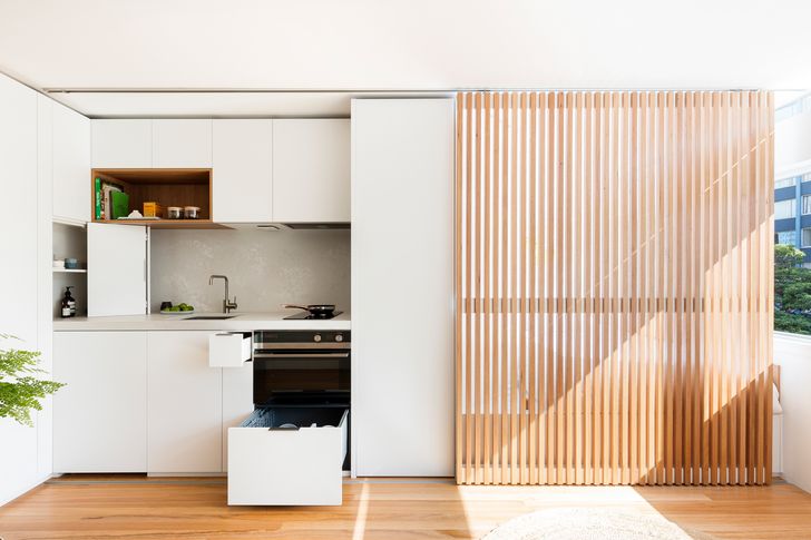 یک صفحه چوبی کشویی در آپارتمان Boneca (2017) با یک حرکت ساده مناطق خواب یا آشپزی را پنهان می کند.
