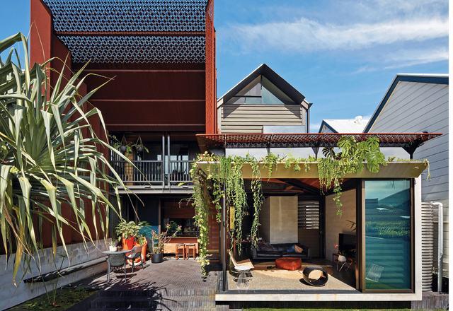 Additions unfold around an outdoor room, framed by a soaring steel portal.