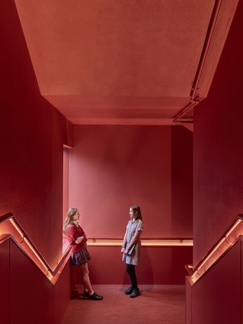 The bold red internal stair at the building’s core constitutes its “beating heart.”