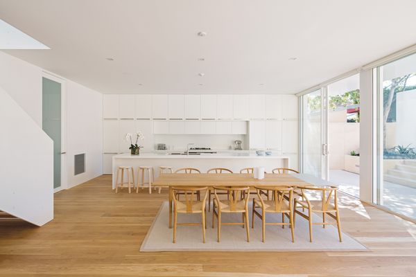 The new living area includes a large kitchen in a crisp, white palette that continues throughout the house.
