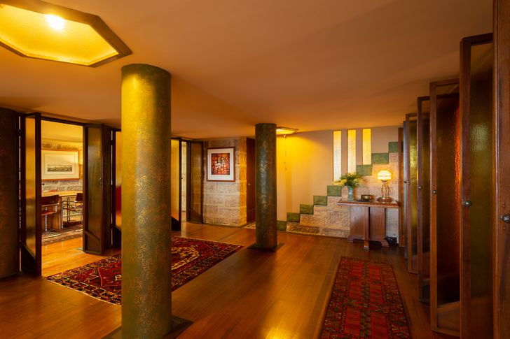 سالن ورودی بزرگ دارای ستون‌هایی از کف تا سقف است که با رنگ‌های سبز و قهوه‌ای اکالیپت استرالیایی با برجسته‌های طلایی متالیک رنگ‌آمیزی شده است.