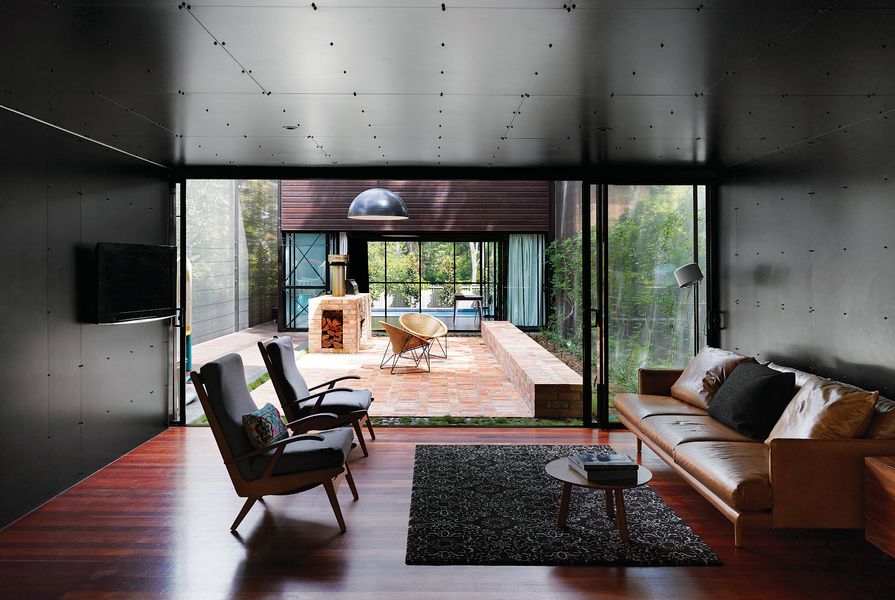 Black melamine lines the interior of the living spaces, which have a strong connection to the outdoor courtyards.