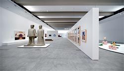 Gallery 1.1, a temporary exhibition space on level one, showing artworks from The 5th Asia-Pacific Triennial of Contemporary Art. To the left of the floating wall are artworks by The Long March Project, and on the right a work by Dinh Q. Lê.