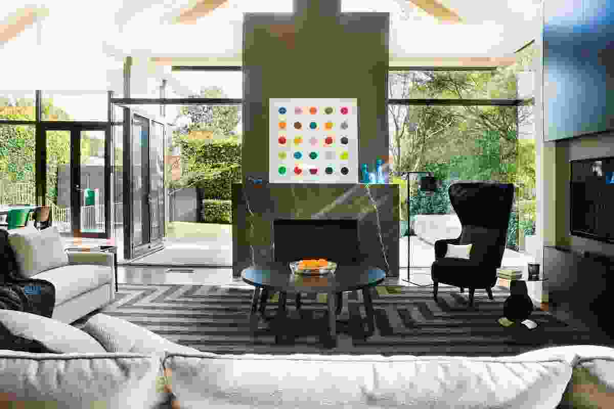 The living room is lit by the rear pavilion. Artwork: Damien Hirst.