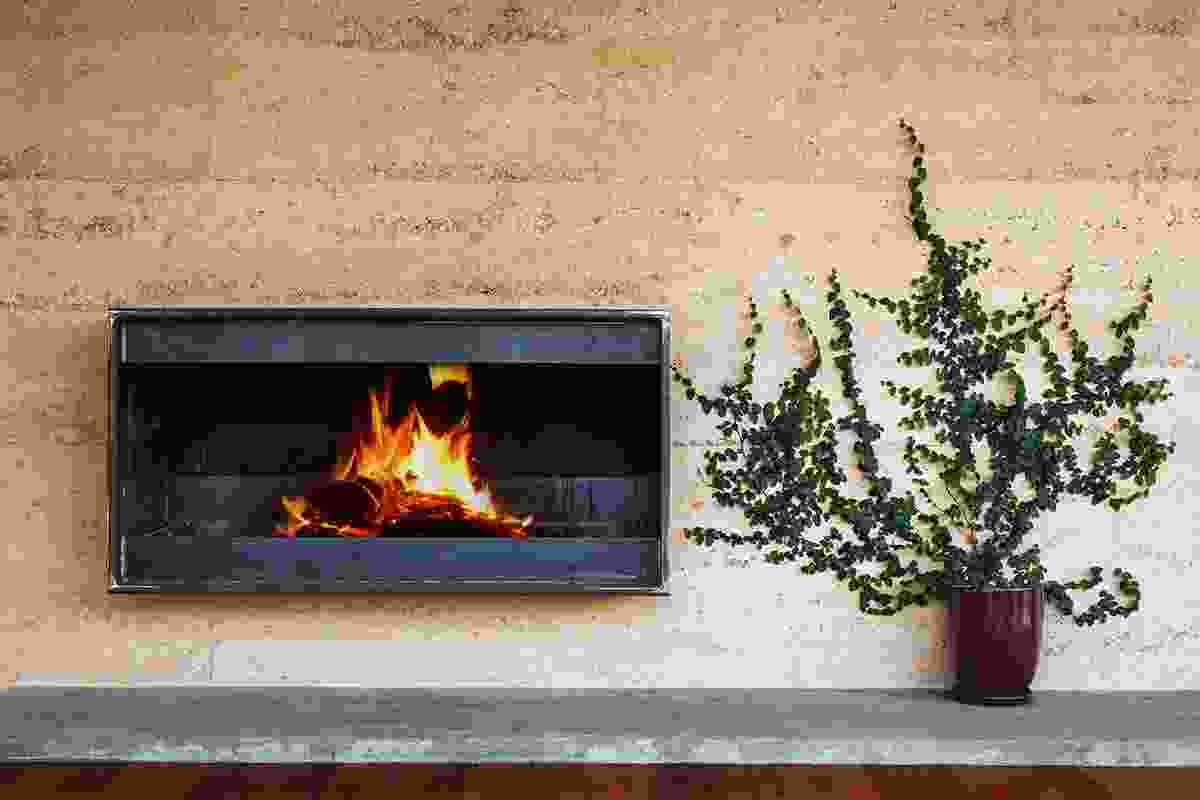 The living area fireplace in the rammed earth wall.  
