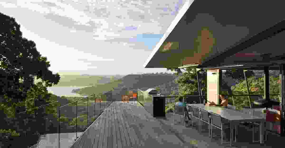 A broad dining deck narrows into a poop deck, the angles of its balustrades drawing focus to the mountains.