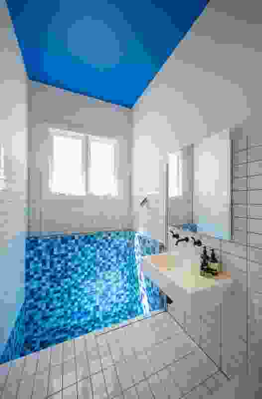 The bathroom features a mosaic of blue tiles.