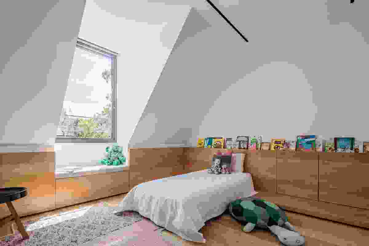 An over-scaled dormer window provides a place to sit and brings light into a child’s bedroom.