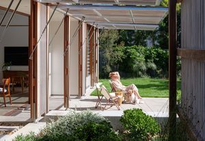 Operable screens along the eastern facade allow living spaces to spill out to the garden.