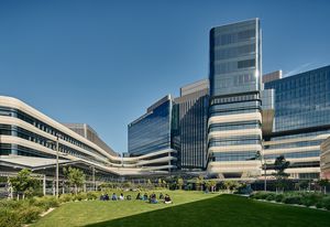 The hospital features a campus-style design with five interconnected buildings arranged around a central green space.