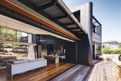 A timber-clad wall continues from the inside to the outside.
