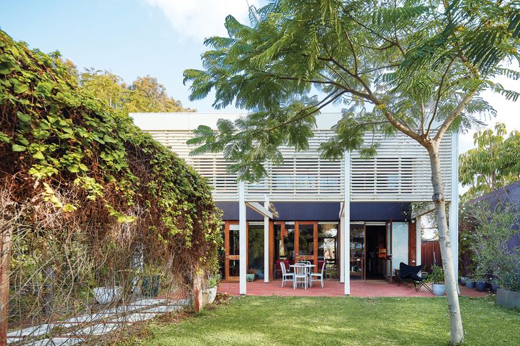 The large white timber structure that replaced the original pergola mediates between garden and house.