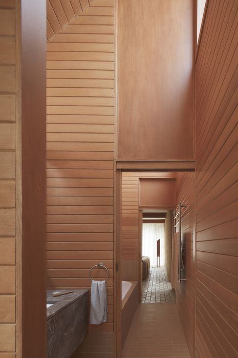 In the main bathroom, functions are organised sequentially beneath a striking skillion roof.