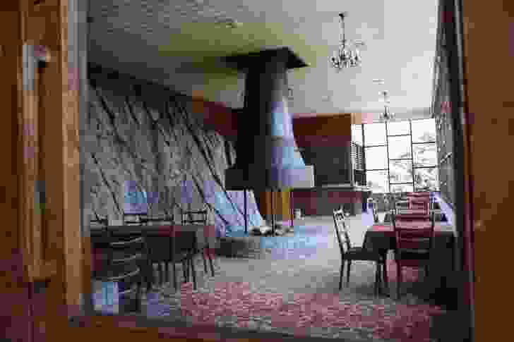 The hotel’s formal dining room (lower level); its mighty rock wall references the mountains.