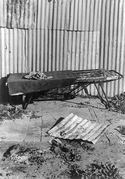 House 49. Clem’s uncle lived in a single-room house built by Clem across the “flat”. The house had no windows and was quite dark. It was often warmer in winter to sit or lie outside in the sun next to a fire spot out of the breeze. In most households bed frames were often moved from room to room and even outside, depending on climate and household population and dynamics.