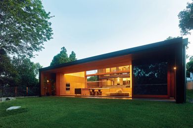 A northern wing with an open living, dining and kitchen space opens onto a garden terrace and verdant landscape.