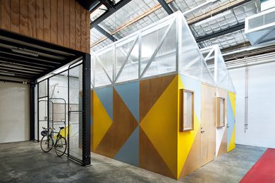 Five small-scale workshop pods act as a tiny precinct within the warehouse space.