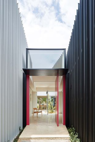 The home is split into two wings that are differentiated externally by colour and separated by a courtyard garden.