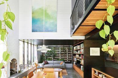 A double-height volume rises over the dining table, filling the depths of the lower level with northern light. Artwork (L-R): Jordy Hewitt; Laura Patterson.