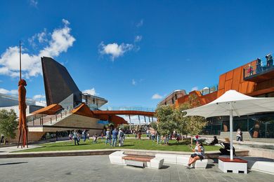 The square manifests as a complex constructed topography of open lawns and jagged architectural forms punctuated by lookouts, ramps and staircases.