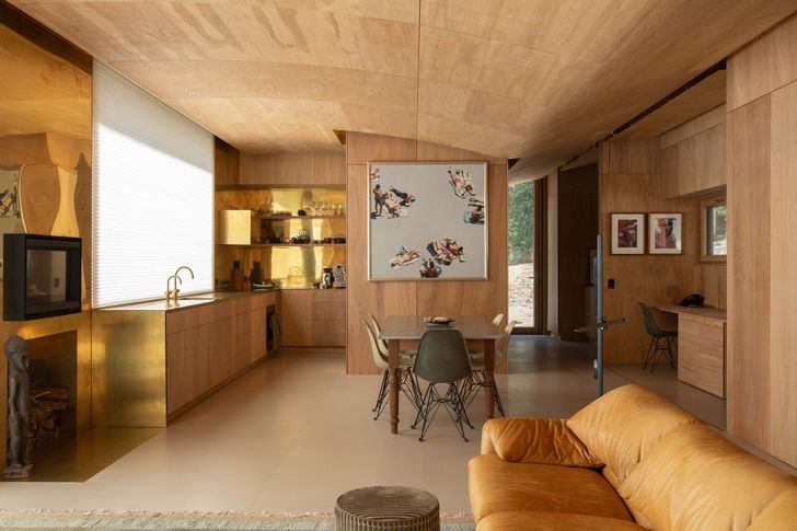 A brass kitchen bench gives the interior a warm glow. Artworks (L–R): Peter Lindsay, Jennifer Nagy.