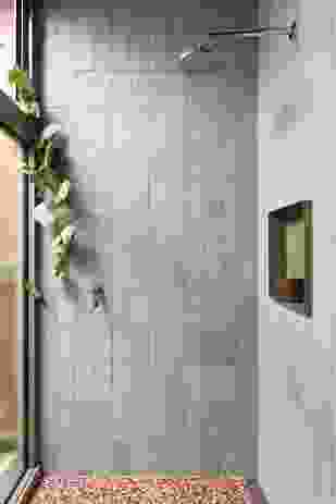 Pale green tiles in the shower recess contrast with the terrazzo floor.