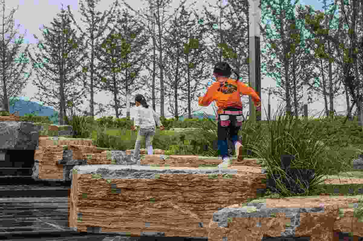 Children play on boulders that reference the Cambrian period of the Palaeozoic era.