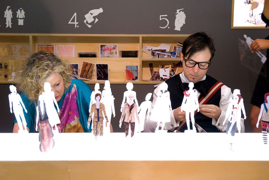 Exhibition-goers design and make their own paper fashion ranges.