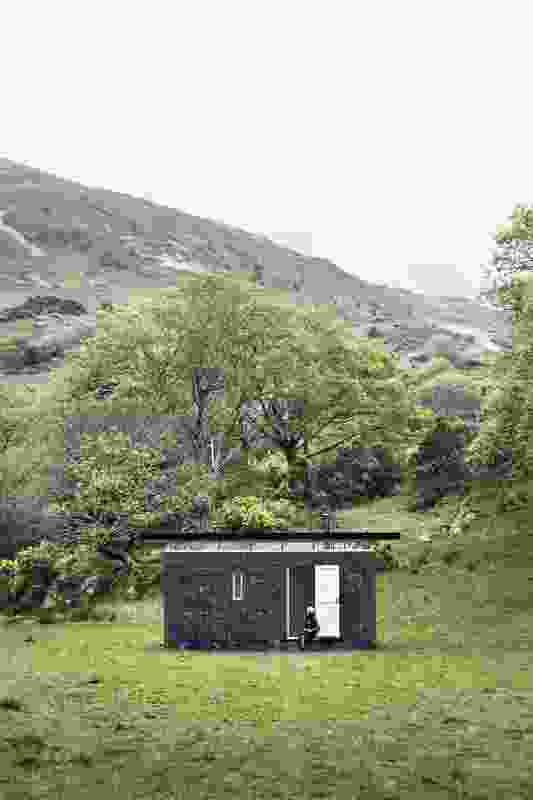 Slate Cabin, a writer’s retreat in Wales, is a reductive black box anchored to the ground, providing protection and respite to visitors.
