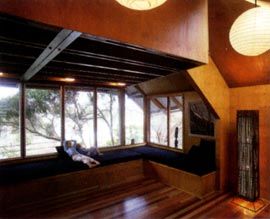 The north-east corner of the living room, wrapped with frameless windows.