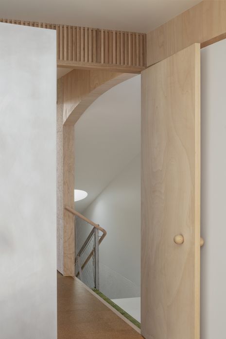 A 250-millimetre gap between the landing and staircase, filled with fibreglass grating, allows light from the upper skylight to filter down to the lower level.