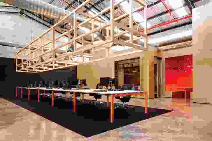 An open timber matrix is suspended above the central workstation.