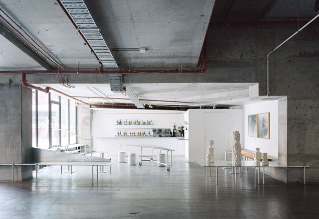 A freestanding central table on castors supports communal seating, and its wedge shape subtly controls movement between the gallery and cafe spaces.