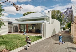 A large sliding gate opens the entire backyard to the adjacent laneway, inviting interaction with passersby and gently blurring the boundary between private and public realms.