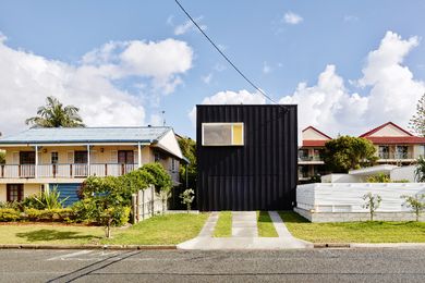 When viewed from the street, the house appears as a dark box clad in compressed fibre cement sheeting and striped with battens.