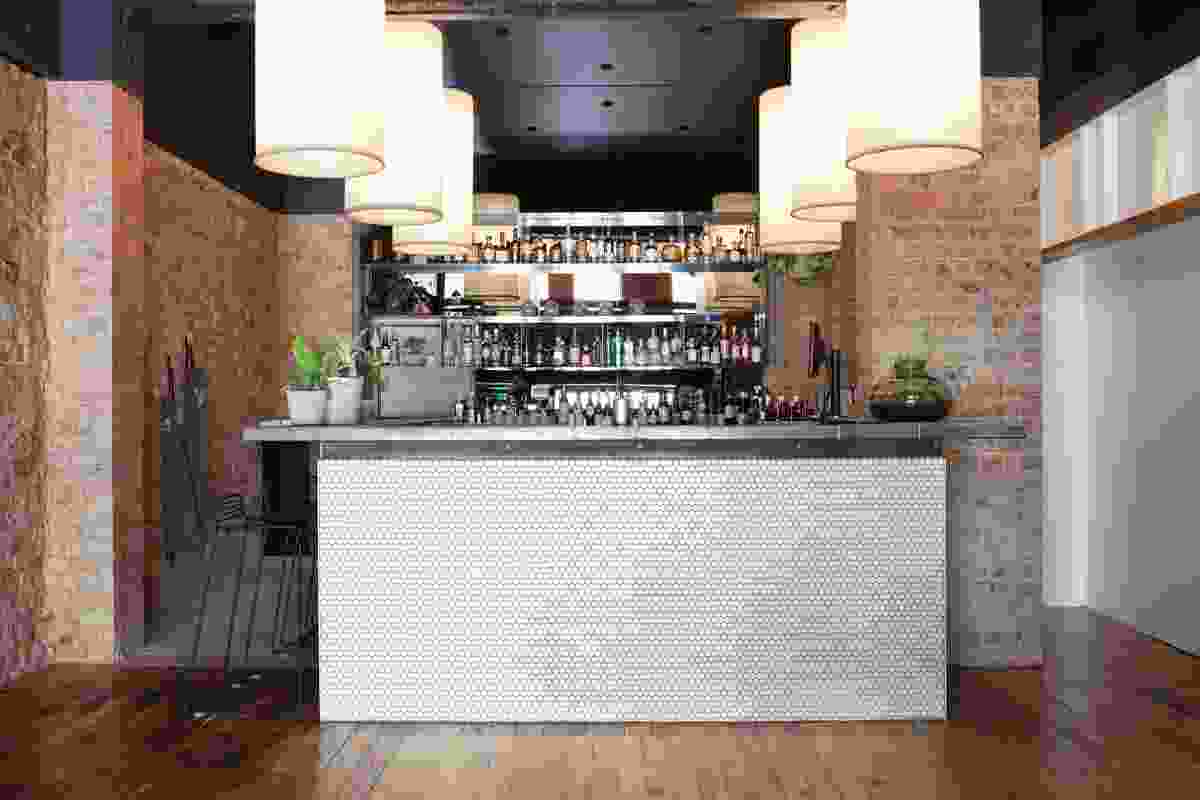 White tiles to the bar front contrast with rough, exposed brick.
