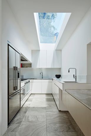 House 3’s otherwise modest and constrained kitchen is filled with light and a sense of space by an expansive skylight.