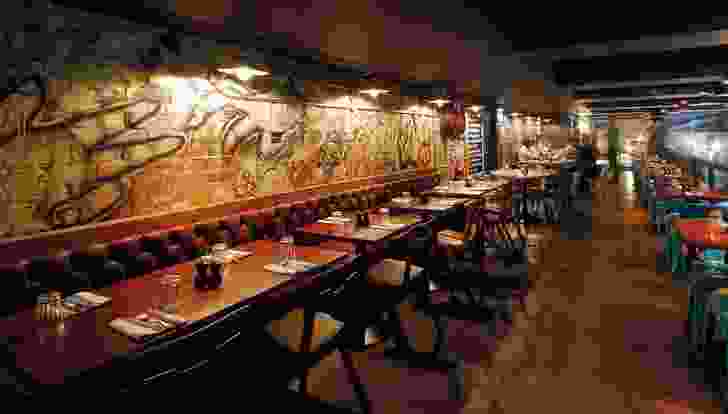 The mezzanine level features a rough brick wall with graffiti behind a banquette.