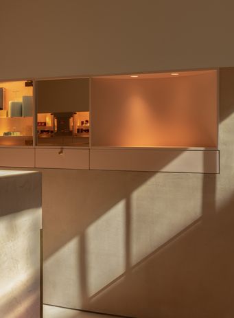 The wall unit is illuminated to make it stand out from its surroundings, directing attention to the product.