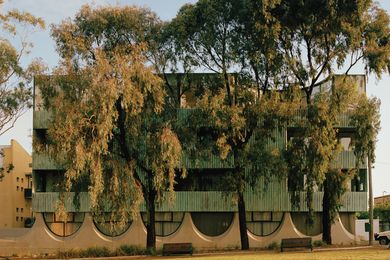 The south facade overlooks a park and Fitzroy Town Hall. Two courtyard houses occupy the top floor, their courtyards seemingly carved out of the glazing.