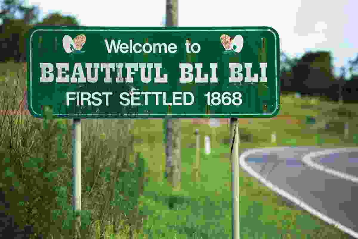 The town sign for Bli Bli on Queensland’s Sunshine Coast welcomes visitors to “Beautiful Bli Bli, first settled 1868,” in a message ornamented with butterflies.