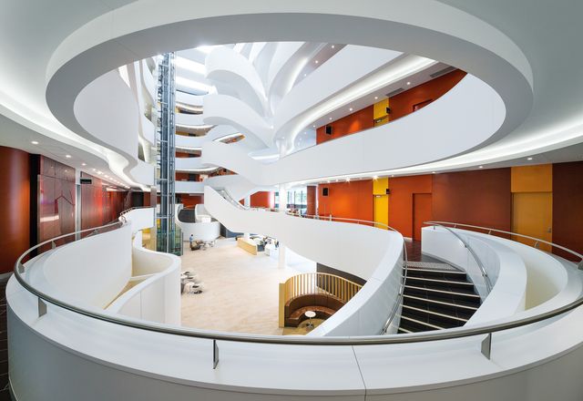 The grand six-storey atrium carves out a glowing white canyon in the centre of the building.