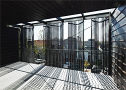 Folding pressed aluminium screens shield the balconies and windows of the north-facing facade. Image: Peter Bennetts